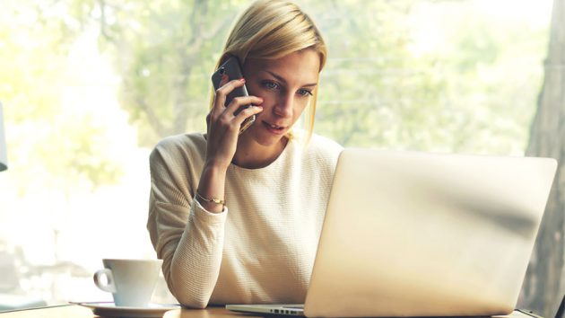 woman on the phone and laptop looking for authorised air conditioner installer