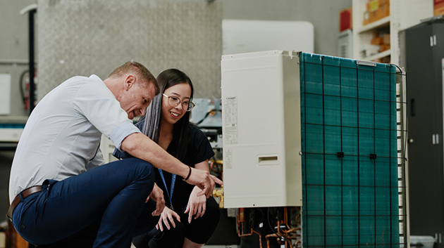 mhiaa technical sales engineer and intern looking at air conditioning unit